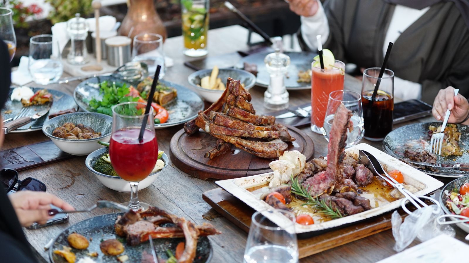Shared grilled-meat platter at an outdoor table, representative food photography